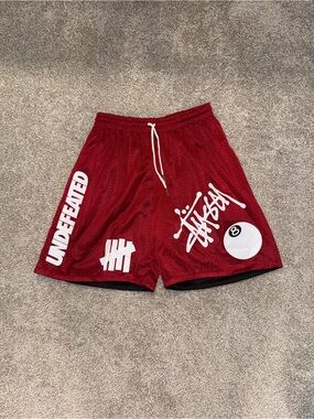 Undefeated Red Mesh Athletic Shorts with White Logo Accents